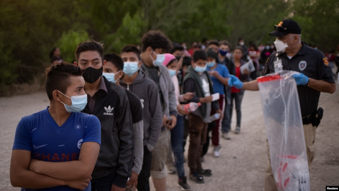 Unaccompanied minors from Central America line up to be transported by U.S. Customs officials, after crossing the Rio Grande into the United States from Mexico on rafts, in Penitas, Texas, March 26, 2021. 