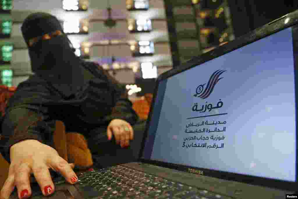 Saudi woman Fawzia al-Harbi, a candidate for local municipal council elections, shows her candidate biography at a shopping mall in Riyadh on Nov. 29, 2015.