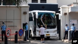 A bus is guided out of the United States Consulate in Chengdu in southwest China's Sichuan province, July 26, 2020.
