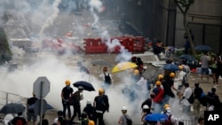 Riot police fire tear gas to protesters outside the Legislative Council in Hong Kong, Wednesday, June 12, 2019. (AP Photo/Vincent Yu)