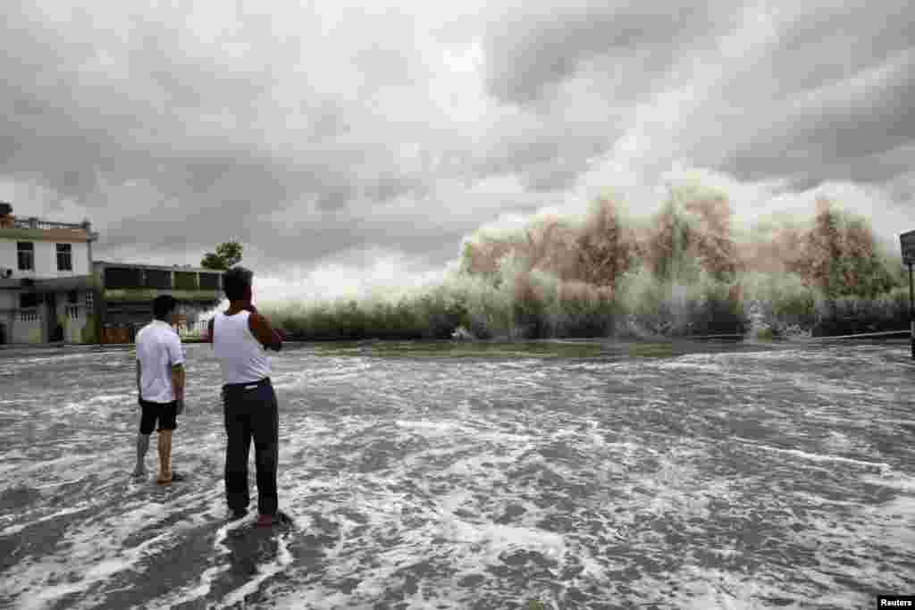 Dua orang pria menonton gelombang besar menghantam pantai saat Topan Usagi mendekati Shantou, Provinsi Guangdong, China.