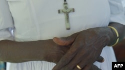 FILE - A South Sudanese woman wears a Catholic cross as she prays during a Mass celebrated at the St. Theresa Cathedral Church Kator, in Juba, March 3, 2019. 