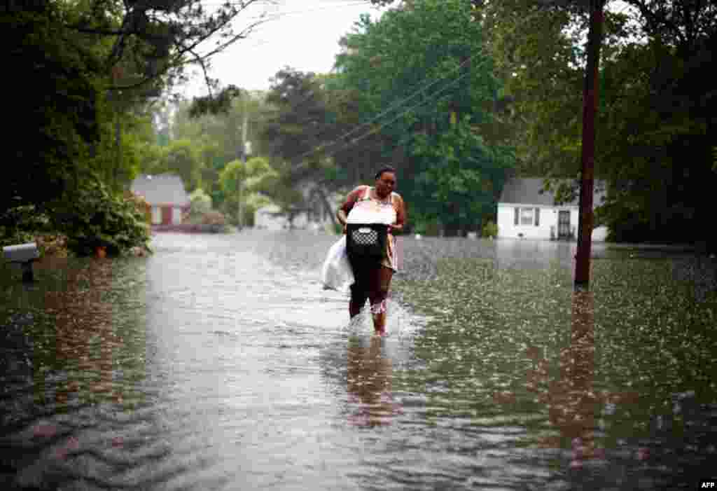 Leandra Felton wades through rising floodwaters with items from her home in Memphis, Tennessee May 7. (Reuters)