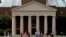 FILE - A group walks across the lawn on the campus of Wake Forest University in Winston-Salem, N.C., May 28, 2014. 