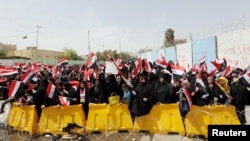 Para pengikut ulama Syiah Moqtada al-Sadr melambaikan bendera Irak dalam aksi protes di Baghdad, Irak, 26 April 2016 (Foto: dok).