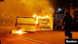 A riot police runs during a demonstration against a constitutional amendment, known as PEC 241, that limit public spending, in Porto Alegre, Brazil, Nov. 11, 2016. The message reads, "Against all authority." 