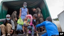 FILE - In this Jan. 19, 2021 file photo, a Honduran migrant child is helped off an army truck after being returned to El Florido, Guatemala, one of the border points between Guatemala and Honduras. The reasons Hondurans continue to flee their…