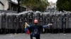 A man kneels in front of police blocking a march called by opposition political leader Juan Guaido in Caracas, Venezuela.