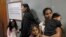 FILE - Asylum seekers Nadeeka Dilrukshi Nonis, right, with her son Dinath and daughter Sethmundi Kellapatha and Vanessa Mae Rodel with her daughter Keana wait at the office of Torture Claims Appeal Board in Hong Kong Monday, July 17, 2017.
