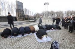 A delegation of Muslim religious leaders perform prayers during a visit to the former Nazi death camp of Auschwitz, in what organizers called “the most senior Islamic leadership delegation" to visit, in Oswiecim, Poland, Jan. 23, 2020.