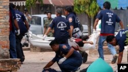 FILE - Volunteer workers remove the bodies of Muslim youths killed in fighting with Thai security officers at Krue Se mosque in Pattani province, southern Thailand April 28, 2004. 