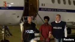 Medhanie Yehdego Mered au centre, 35 ans, est entouré par deux policiers italiens à l'aéroport de Palerme, Italie, après son arrestation à Khartoum, Soudan, le 24 mai 2016.