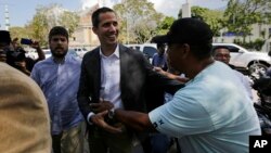 Venezuelan Congress President Juan Guaido, an opposition leader who has declared himself interim president, greets a supporter as he arrives to meet with public employee unions in Caracas, March 5, 2019. 