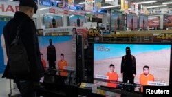 FILE - A man watches a news program about an Islamic State video purporting to show two Japanese captives at an electronics store in Tokyo, January 20, 2015. 