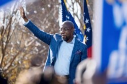 FILE - Democratic U.S. Senate challenger the Rev. Raphael Warnock waves during a rally in Columbus, Ga., Dec. 21, 2020.