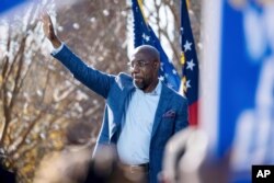 FILE - Democratic U.S. Senate challenger the Rev. Raphael Warnock waves during a rally in Columbus, Ga., Dec. 21, 2020.
