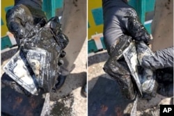 In these still images from video, magnet fisher James Kane displays the part of the contents of a safe he pulled out of a pond, in Flushing Meadows Corona Park, in the Queens borough of New York, Friday May 31, 2024. (James Kane and BarbI Agostini @LetsGetMagnetic via AP)