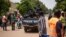 FILE - Police officers drive by during a march called by the opposition to protest the worsening security situation, in Ouagadougou, on July 3, 2021. 