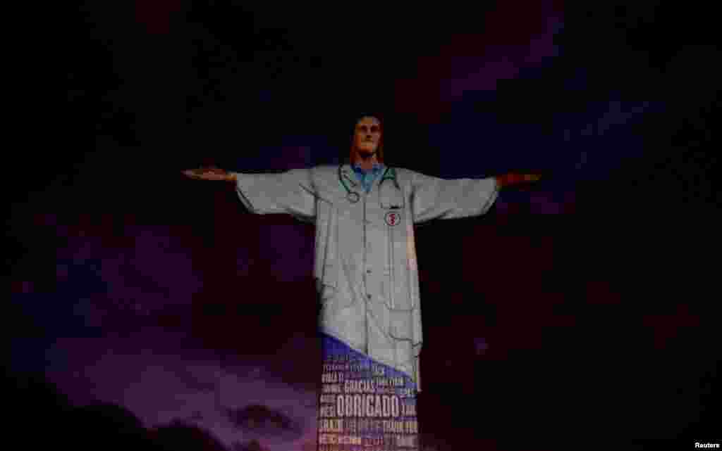 The statue of Christ the Redeemer is lit up with the image of a medical scrub and the word "thank you" in different languages during an Easter Sunday event in Rio de Janeiro, Brazil, April 12, 2020.