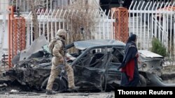아프간 수도 카불에서 보안 경찰이 폭탄 테러로 파손된 차량을 조사하고 있다.