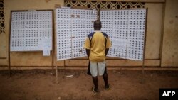 Un homme devant les listes d’électeurs dans un centre de vote, durant la présidentielle, a Libreville, le 27 août 2016.