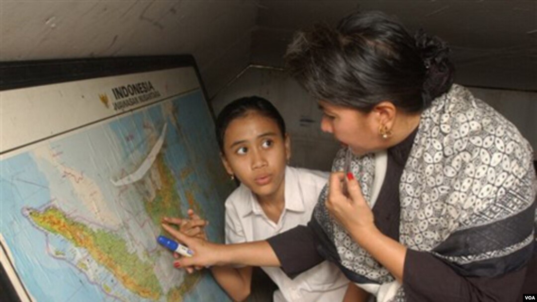 Sri Rosiyanti mengajar seorang anak perempuan di sekolah terbuka yang ia dirikan bersama saudara kembarnya Sri Irianingsih. Angka terbaru menunjukkan lebih dari lima juta perempuan Indonesia mengalami buta aksara. (foto: dok)