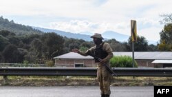 FILE - A member of the community police patrols the road in Cheran, Michoacan state, Mexico, Dec. 11, 2019.
