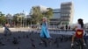 Una artista disfrazada como Elsa de Arendelle, el personaje de Disney, camina por la plaza frente al Palacio Nacional en el centro histórico de San Salvador, El Salvador, el miércoles 24 de enero de 2024. (Foto AP/Salvador Meléndez).