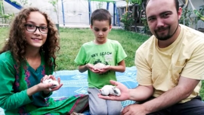 Esta foto familiar muestra a Ryan Corbett sosteniendo conejos con su hija Miriam y su hijo Caleb en Kabul, Afganistán, en 2020.AP