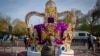 Une femme prend des photos d'une installation artistique représentant la couronne de Saint Édouard à Londres, le mercredi 3 mai 2023.