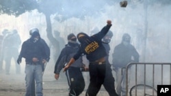 A demonstrator throws a stone during a demonstration of the 'Indignant' group in Rome October 15, 2011. Protesters worldwide geared up for a cry of rage on Saturday against bankers, financiers and politicians they accuse of ruining global economies and co