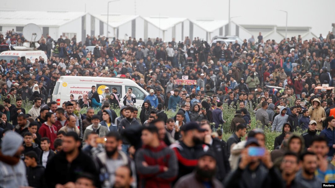 Warga Palestina tampak berkumpul memperingati Hari Tanah Air dan peringatan satu tahun unjuk rasa perbatasan di pagar timur perbatasan Israel-Gaza, Kota Gaza, 30 Maret 2019. 