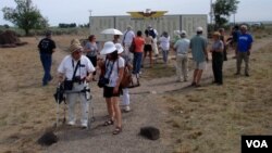 Minidoka "pilgrims" admire the re-created Honor Roll, which stood near the camp entrance and listed the names of internees who joined the U.S. armed forces during WWII, near Twin Falls, Idaho. (VOA / T. Banse)