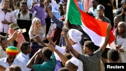 Sudanese demonstrators celebrate after Defense Minister Awad Ibn Auf stepped down as head of the country's transitional ruling military council, as protesters demanded quicker political change, near the Defense Ministry in Khartoum, Sudan, April 13, 2019.