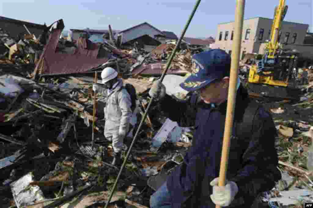 Local firefighting volunteers seek survivors at the devastated Noda village, northern Japan, Monday, March 14, 2011, three days after a powerful earthquake-triggered tsunami hit the country's east coast. (AP Photo/The Yomiuri Shimbun, Yoichi Hayashi) JAPA