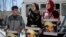 FILE - Relatives of Palestinian teenager Mohammed Abu Khdeir who was killed in 2014, hold posters bearing his portrait outside the Jerusalem district court during a hearing on Feb. 4, 2016. 