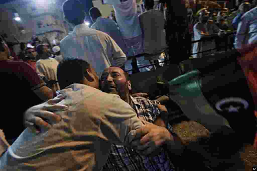 Libyans embrace each other as tens of thousands of Libyans celebrate the arrest of Qaddafi's son Saif al-islam and the fall of Tripoli to the Libyan rebels on Aug. 21, 2011 in Benghazi, Libya. (AFP)