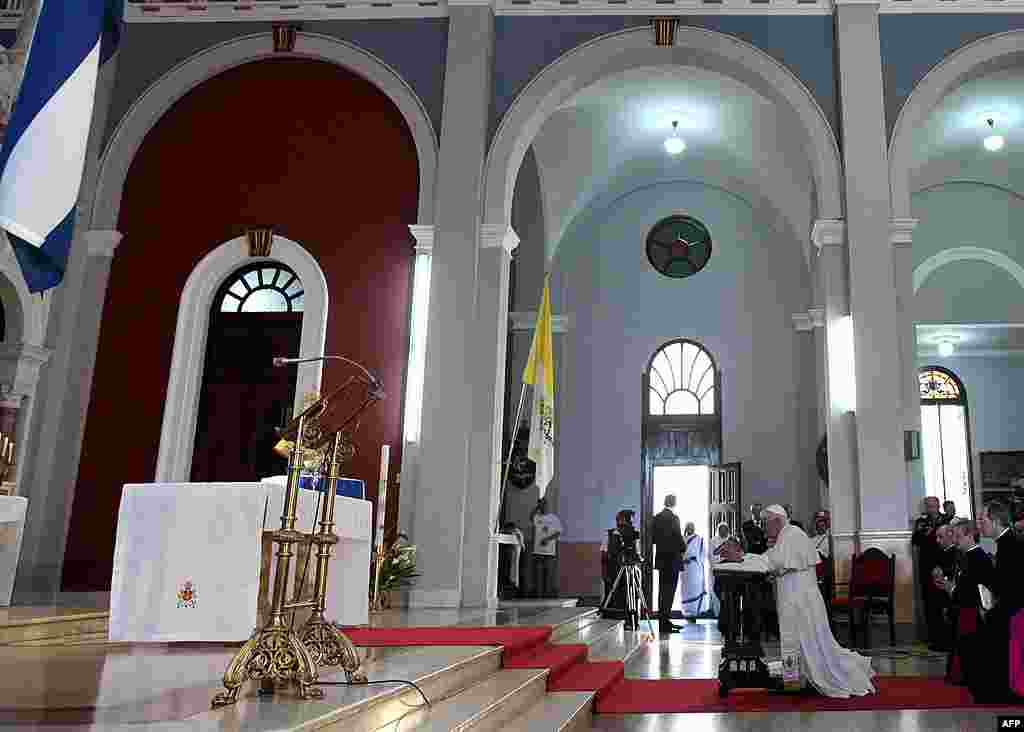 Pope Benedict kneels before the Virgin of Charity of Cobre, Cuba's patron saint, in Santiago de Cuba, Cuba, March 27, 2012. (AP)