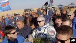 El astronauta estadounidense Steve Swanson es cargado por especialistas a su aterrizaje en Kazakstan.