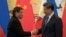 FILE - Philippine President Rodrigo Duterte (L) and Chinese President Xi Jinping shake hands after a signing ceremony held in Beijing, Oct. 20, 2016. 
