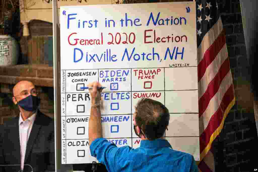 A man tallies the votes from the five ballots cast just after midnight, in Dixville Notch, New Hampshire.