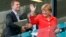 FILE - German Chancellor Angela Merkel waves after watching the group G World Cup soccer match between Germany and Portugal at the Arena Fonte Nova in Salvador, Brazil, June 16, 2014.