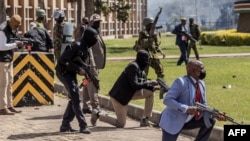 Kenya Police officers and security personnel take position to protect the Kenyan Parliament as protesters try to storm the building during a nationwide strike to protest against tax hikes and the Finance Bill 2024 in downtown Nairobi, on June 25, 2024.