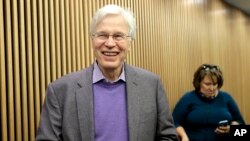 FILE - Finnish Professor Bengt Holmstrom of the Massachusetts Institute of Technology smiles as he departs a news conference after speaking to members of the media on the campus of MIT in Cambridge, Massachusetts, Oct. 10, 2016.