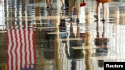 Una bandera estadounidense se refleja en el suelo en el Aeropuerto Nacional Reagan en Washington, el 1 de julio de 2016.