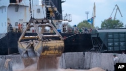 ARCHIVO - Trabajadores cargan grano en un puerto en Izmail, Ucrania, el 26 de abril de 2023. Rusia anunció el lunes 17 de julio que paralizaba su participación en el acuerdo de guerra que permitía exportar grano ucraniano, en un revés a la seguridad alimentaria global.