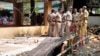 Police personnel stand at the spot where an explosion occurred Monday night when a fireworks storage facility caught fire injuring several people during a festival at Veerarkavu Hindu temple, at Neeleswaram, Kasargod district, Kerala, India, Oct.29, 2024.