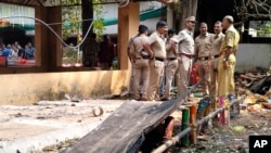 Police personnel stand at the spot where an explosion occurred Monday night when a fireworks storage facility caught fire injuring several people during a festival at Veerarkavu Hindu temple, at Neeleswaram, Kasargod district, Kerala, India, Oct.29, 2024.