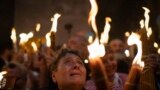 FILE—A Christian Orthodox pilgrim holds a candle during the Holy Fire ceremony at the Church of the Holy Sepulchre, where many Christians believe Jesus was crucified, buried and rose from the dead, in the Old City of Jerusalem. Saturday, May 4, 2024. 
