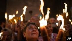 FILE—A Christian Orthodox pilgrim holds a candle during the Holy Fire ceremony at the Church of the Holy Sepulchre, where many Christians believe Jesus was crucified, buried and rose from the dead, in the Old City of Jerusalem. Saturday, May 4, 2024. 